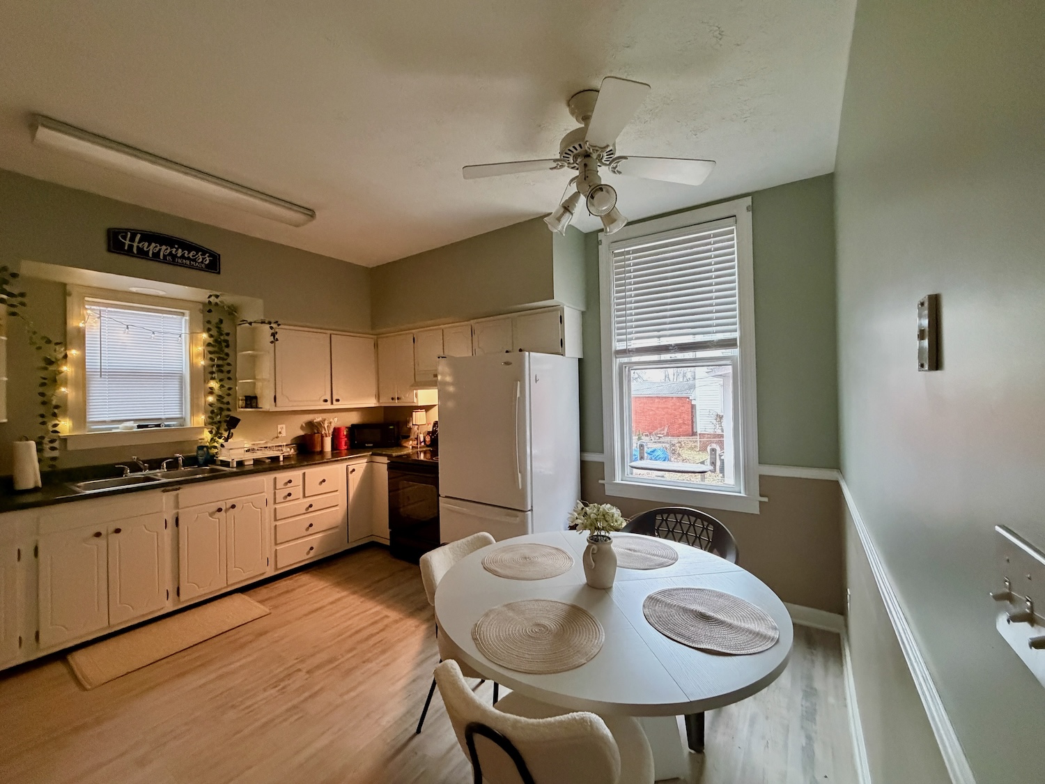 A comfortable, open kitchen with room to gather. Spacious first-floor kitchen and dining area in a Huntington quad with white cabinetry and natural light.