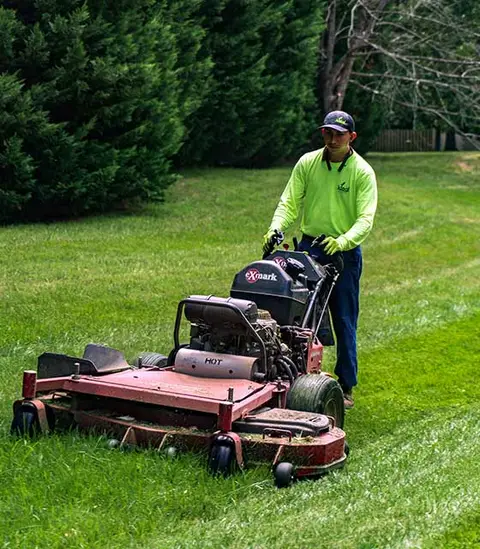 A home lawn care worker mowing a large yard