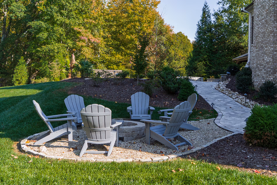 A backyard patio and stone walkway completed with landscaping services Greensboro NC.