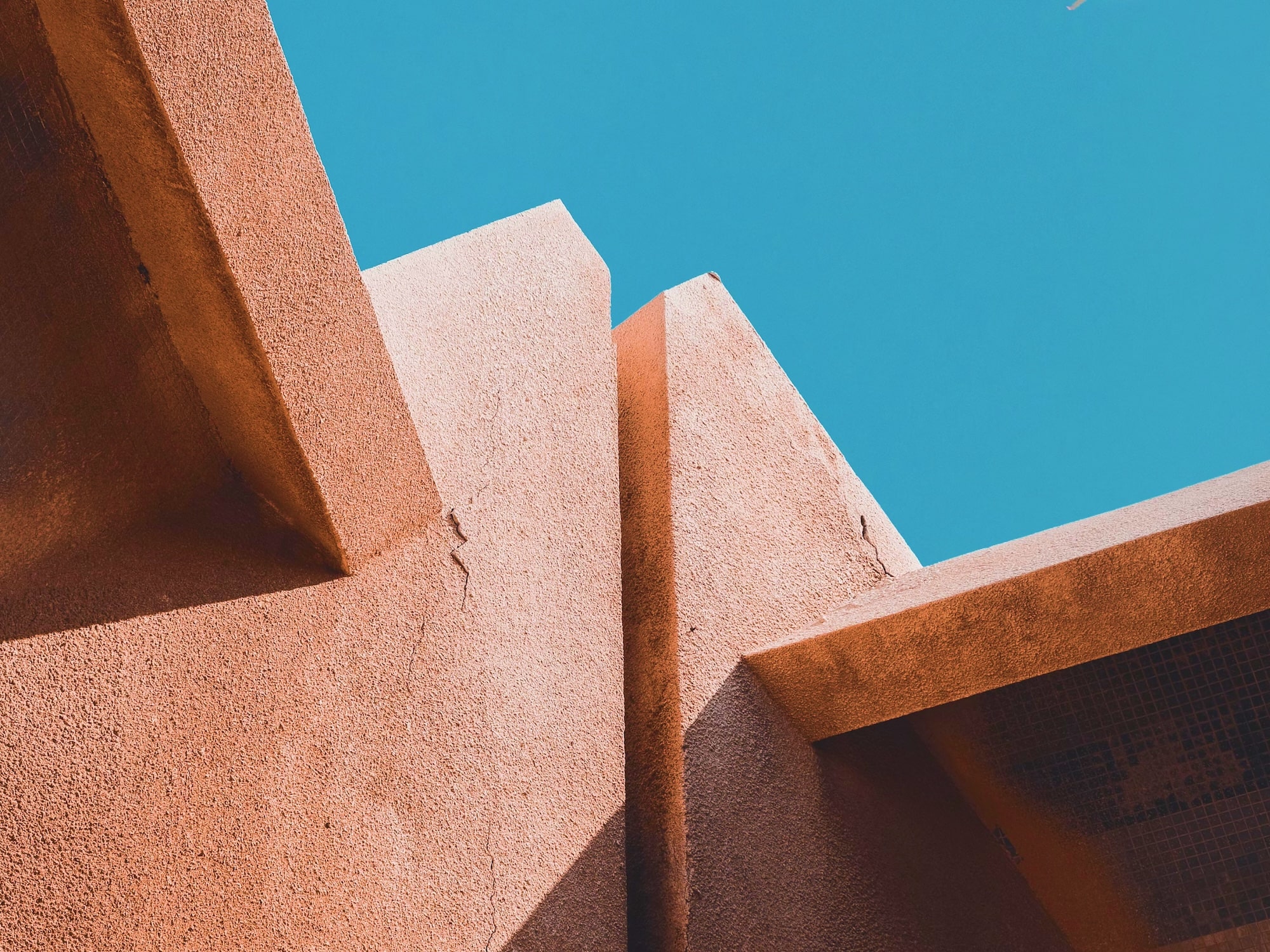Abstract architectural photograph of adobe-style walls against a blue sky, used as portfolio placeholder imagery