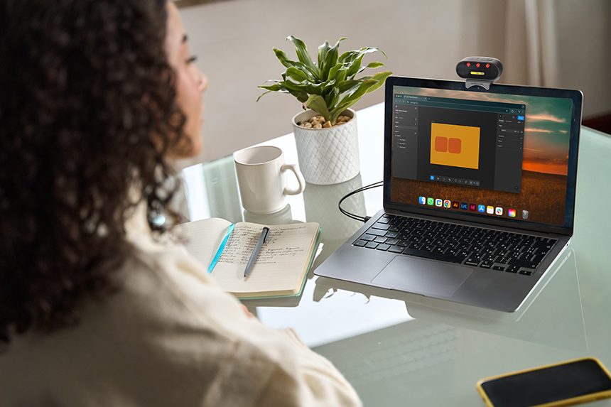 Sunbooster near-infrared light mounted on a laptop during desk work