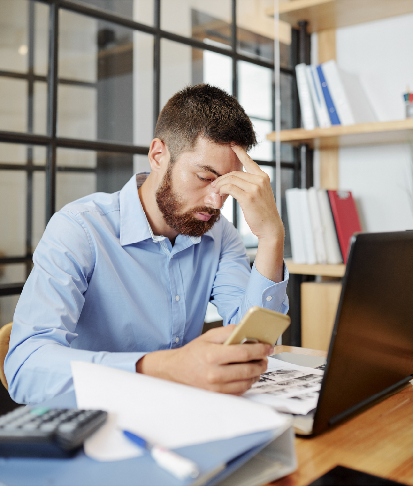 Business owner dealing with software problem on laptop and phone