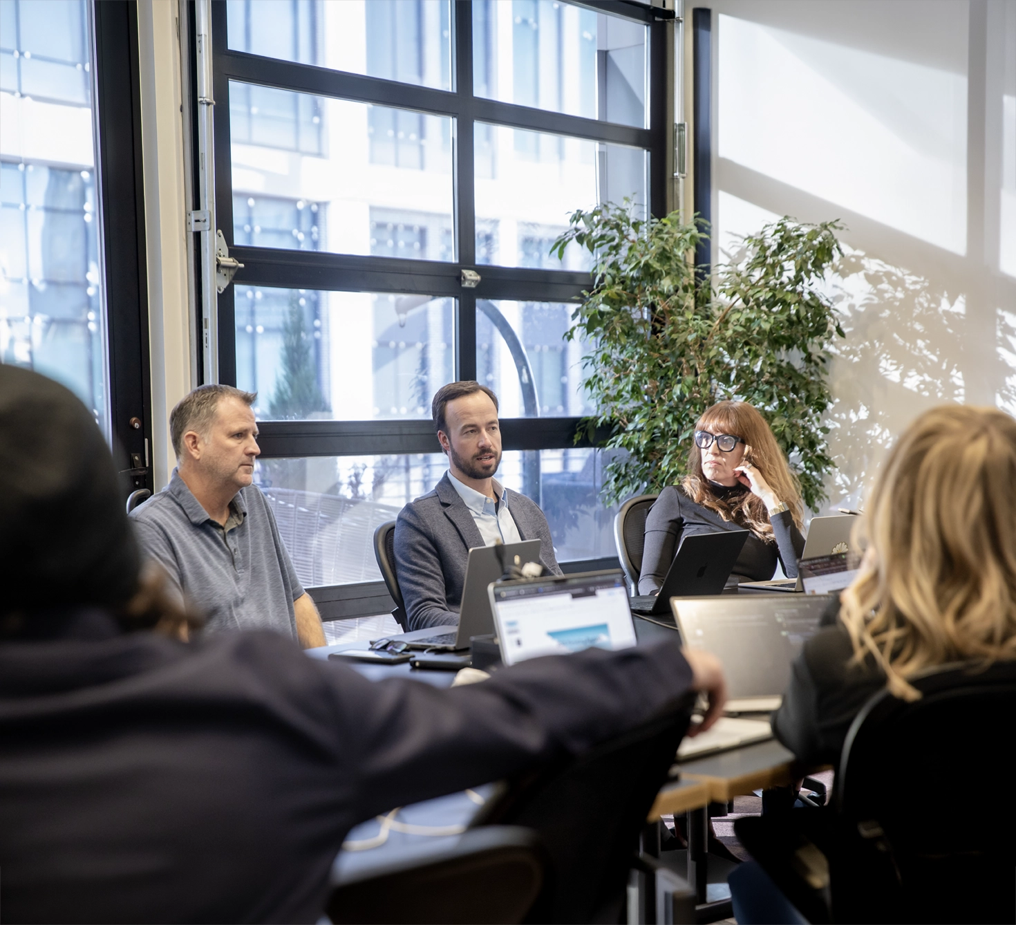 303 Software team members collaborating in a conference room with laptops during a client project planning session.