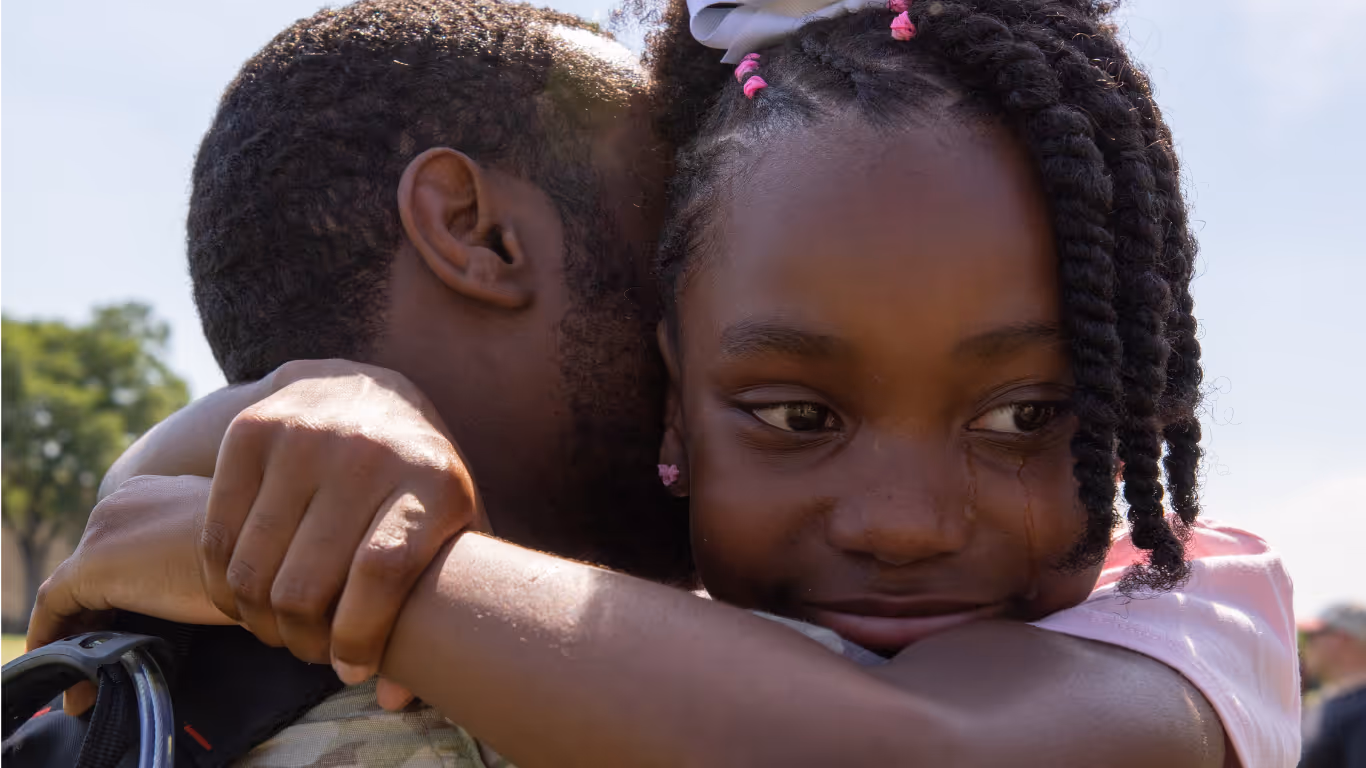 A man and a girl hugging each other.