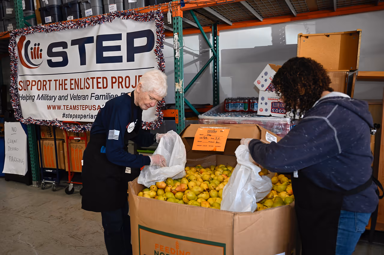 Two women are unloading boxes of lemons.