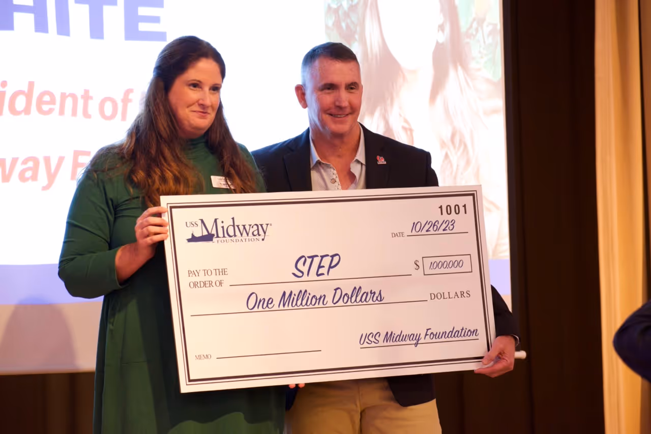 A man and a woman are holding a check for one million dollars.