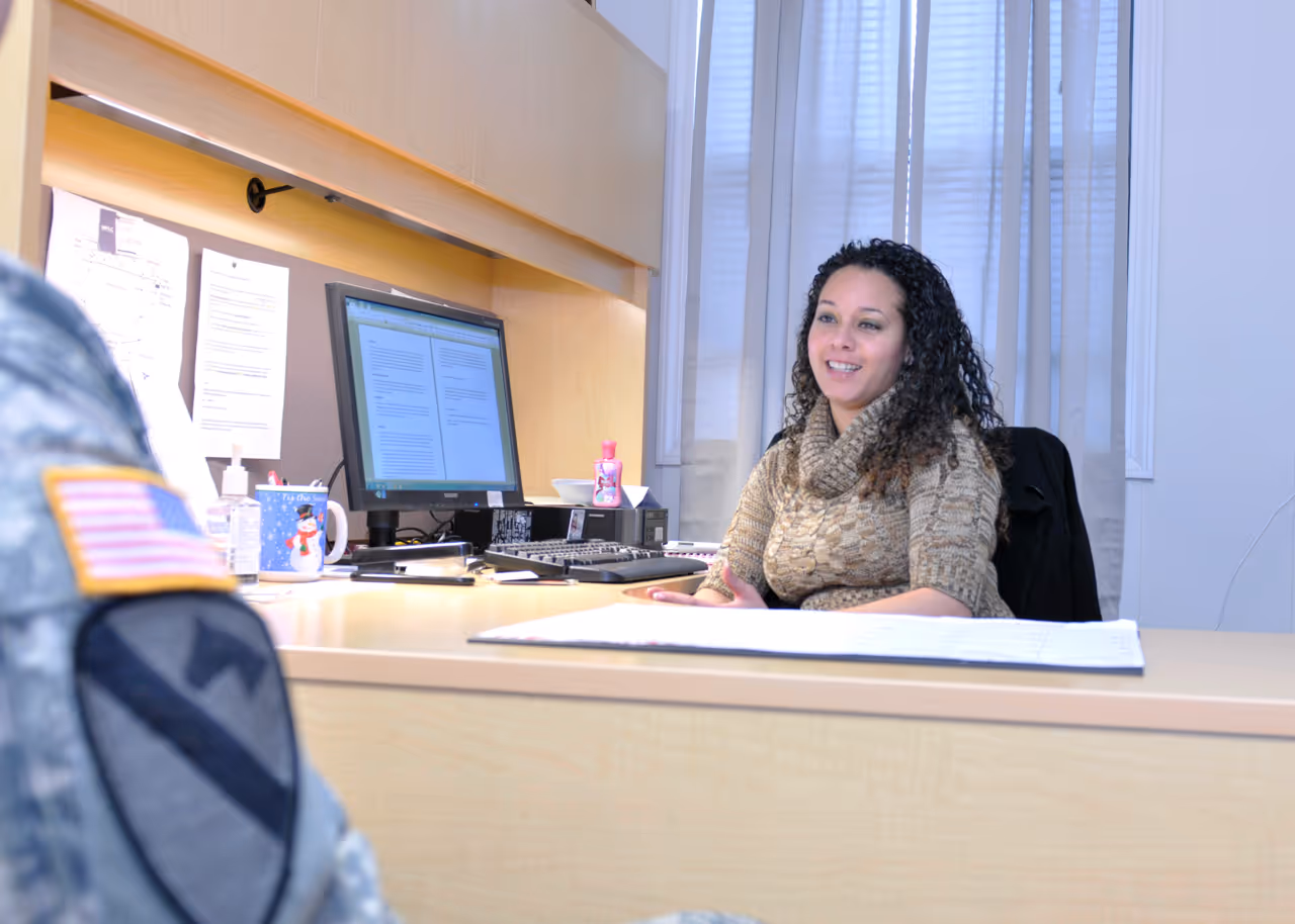 A woman sitting at a desk with a computer.