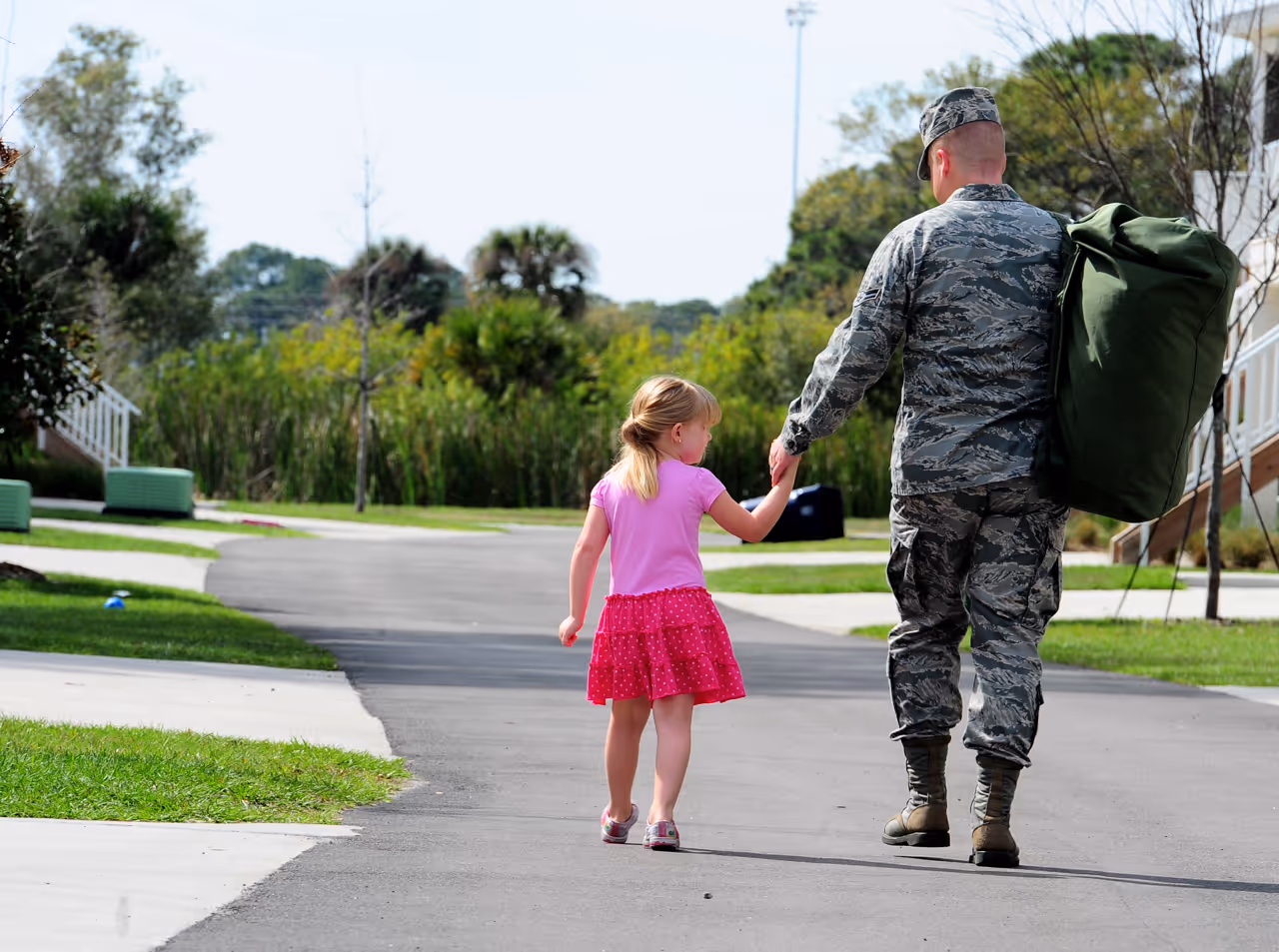 A man and a girl walking down a street.