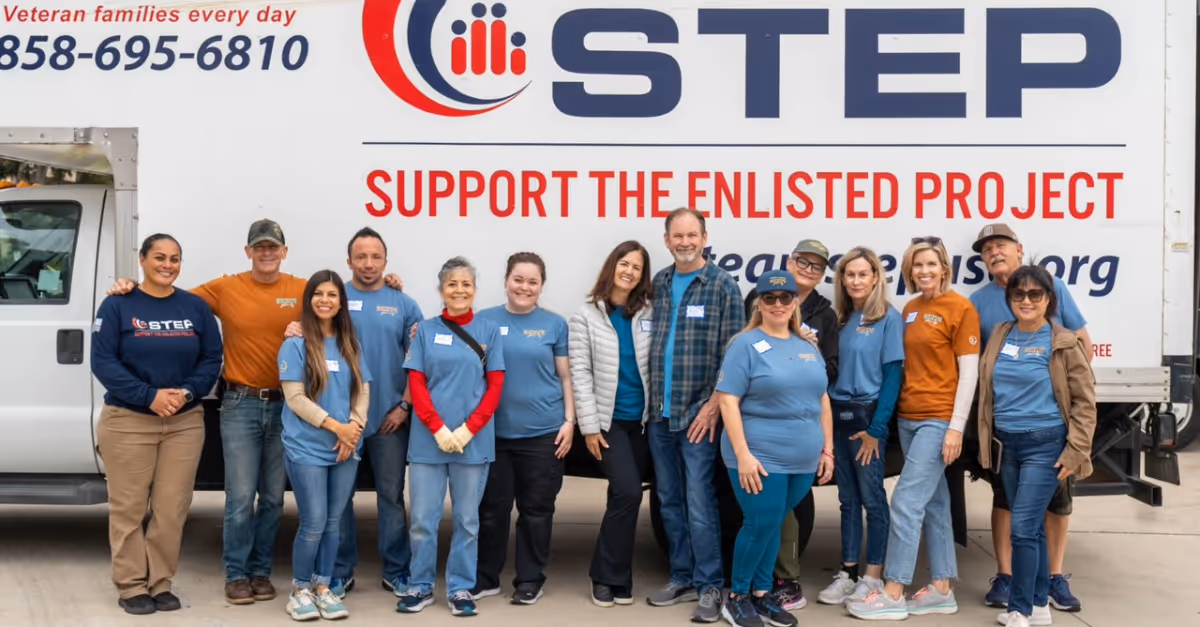 A group of volunteers standing in front of a truck that says Steel.