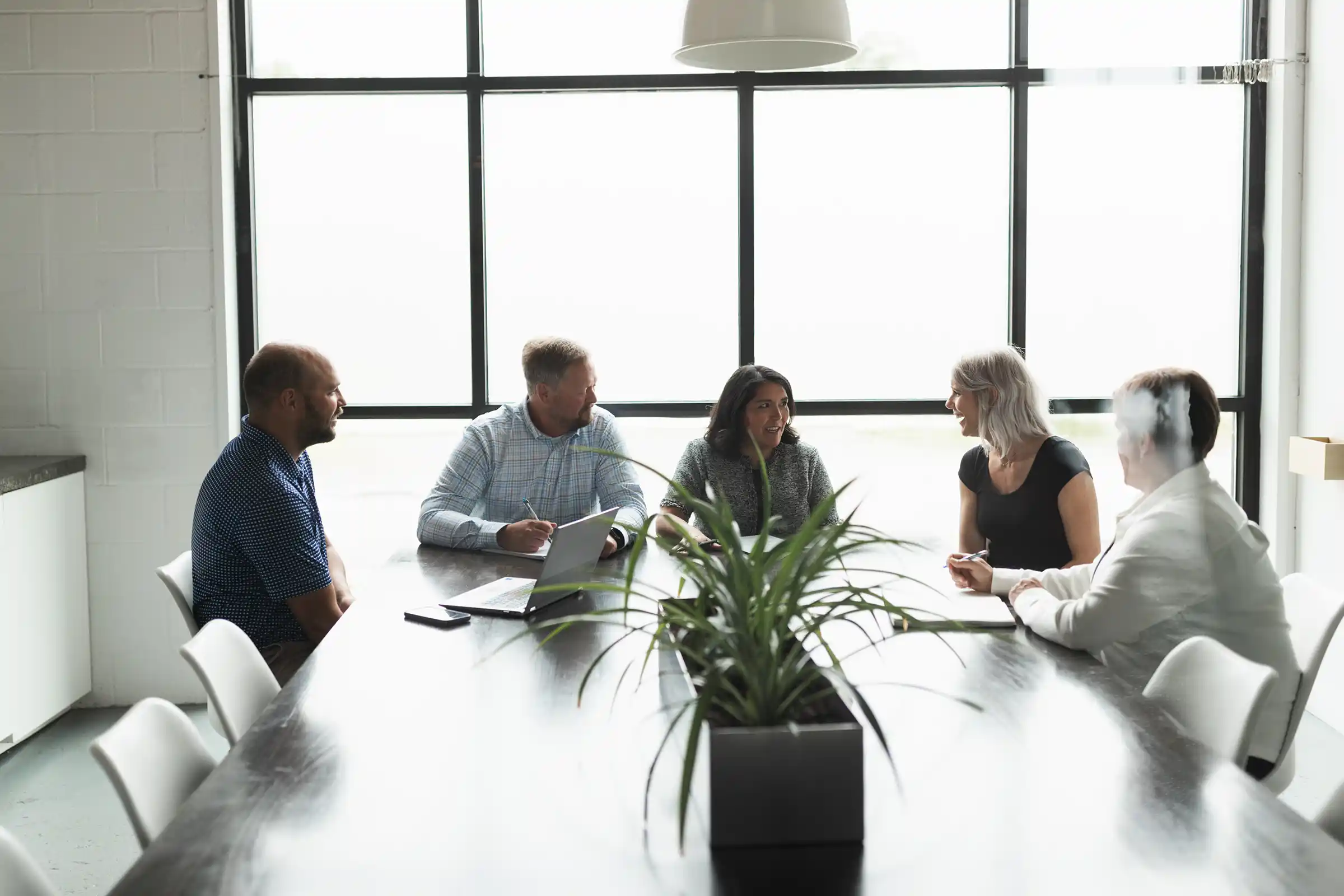 Five professionals engaged in a strategic planning meeting at KWT Consulting, developing leadership growth and organizational transformation plans.