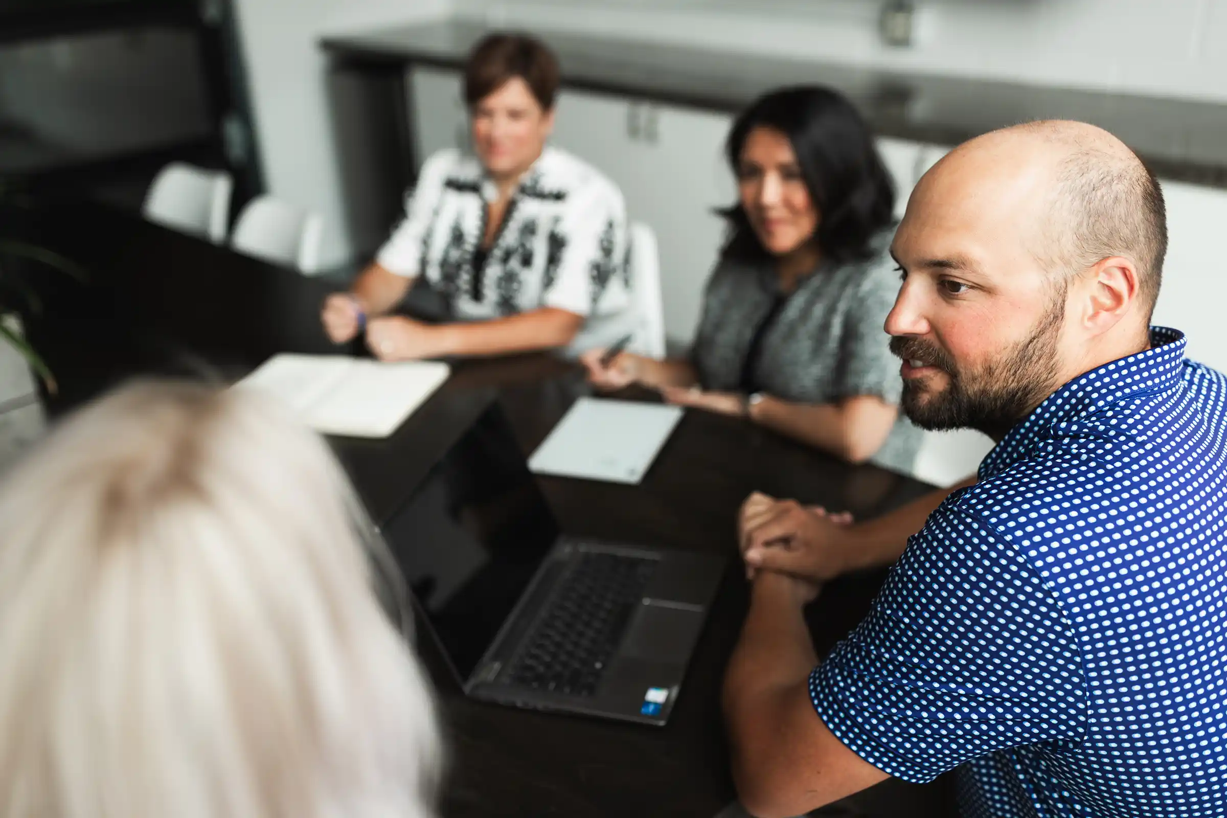 A team collaborating in a strategy session, discussing HR and talent strategy to improve leadership alignment and reduce conflict.