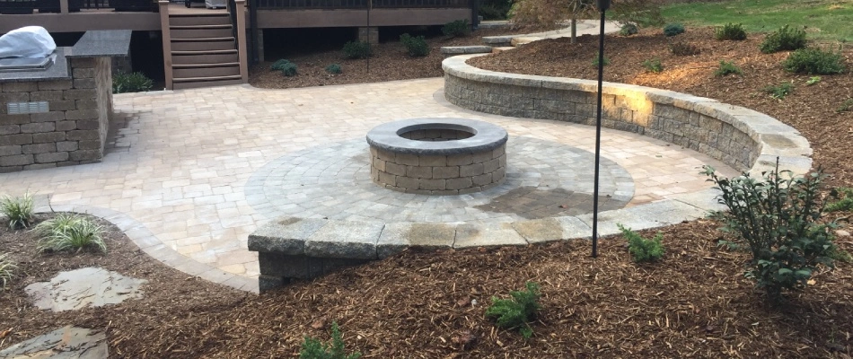 Sloped property with a retaining wall installed to prevent soil erosion in Greensboro, NC.