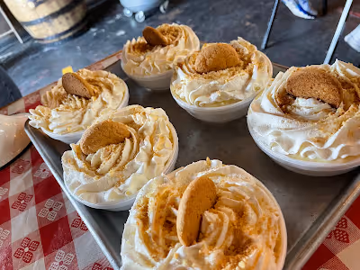 A tray of assorted cupcakes topped with whipped cream and decorated with cookies.