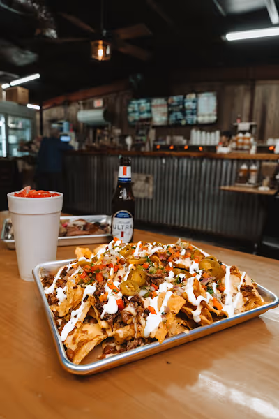 A person holding a tray with a piece of food, showcasing a casual dining or serving scenario.