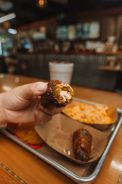  A person holding a tray with a piece of food, showcasing a casual dining or serving scenario.