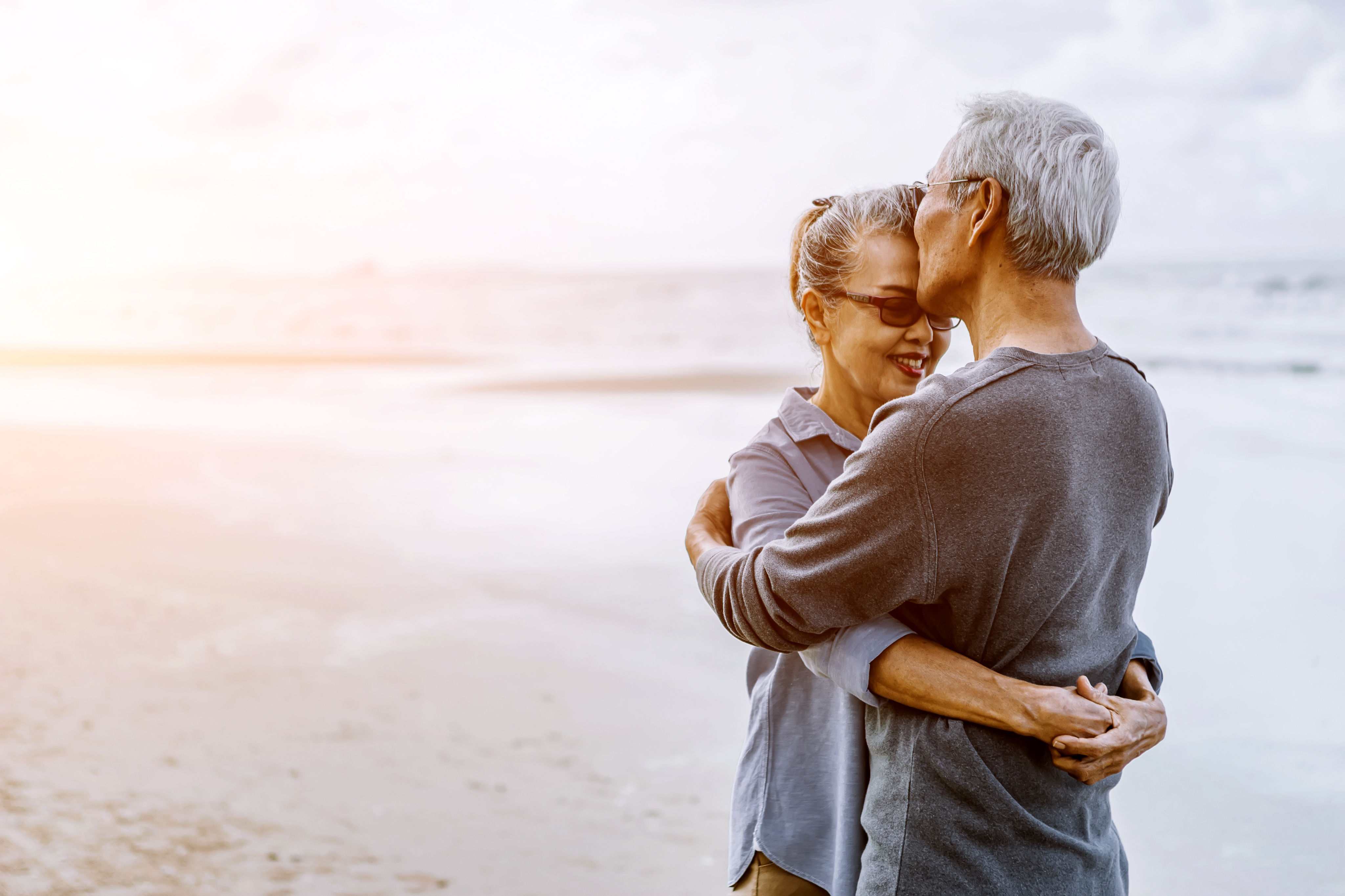 Older couple embracing on a beach
