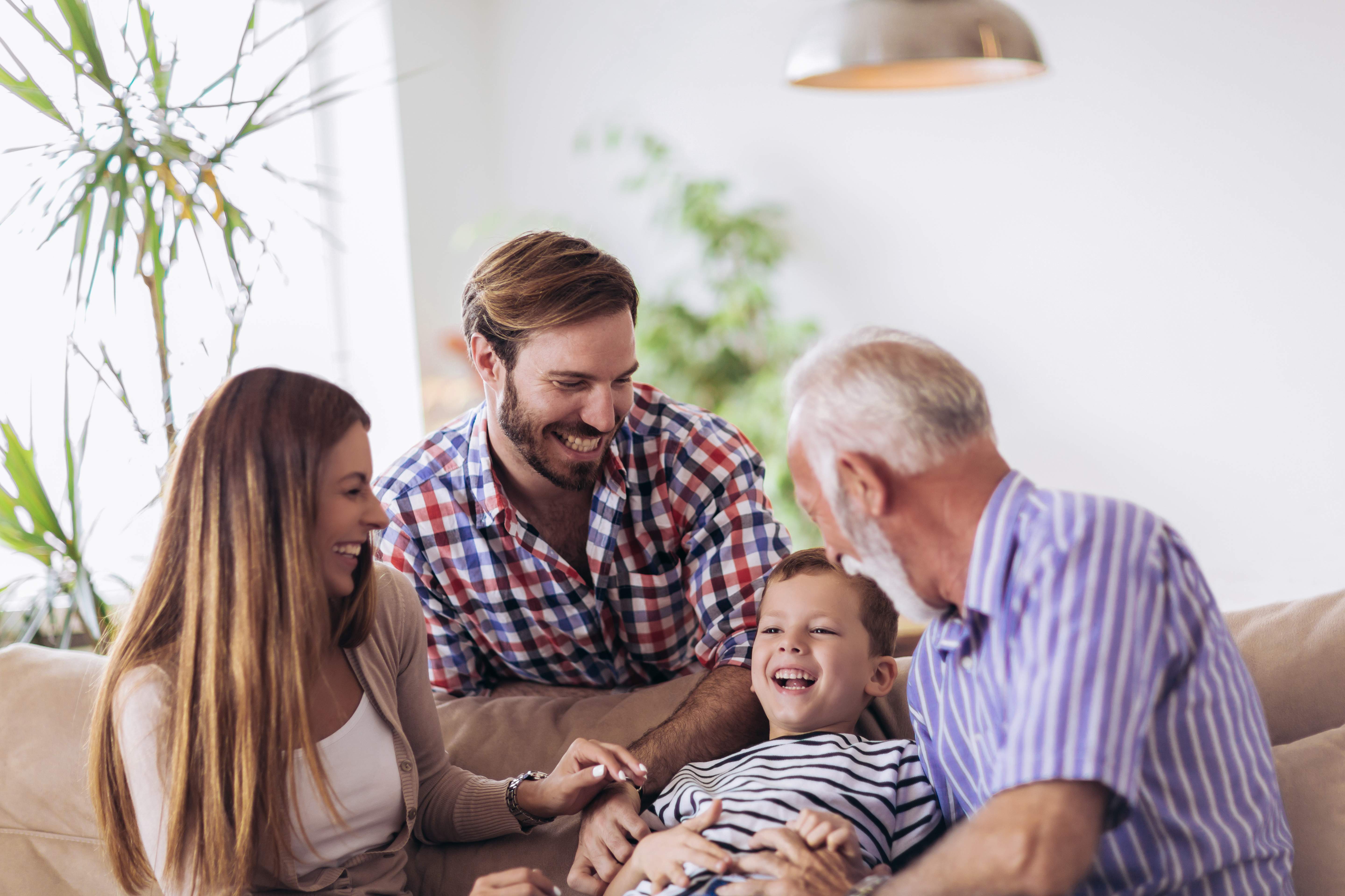 An adult son laughing with his older father