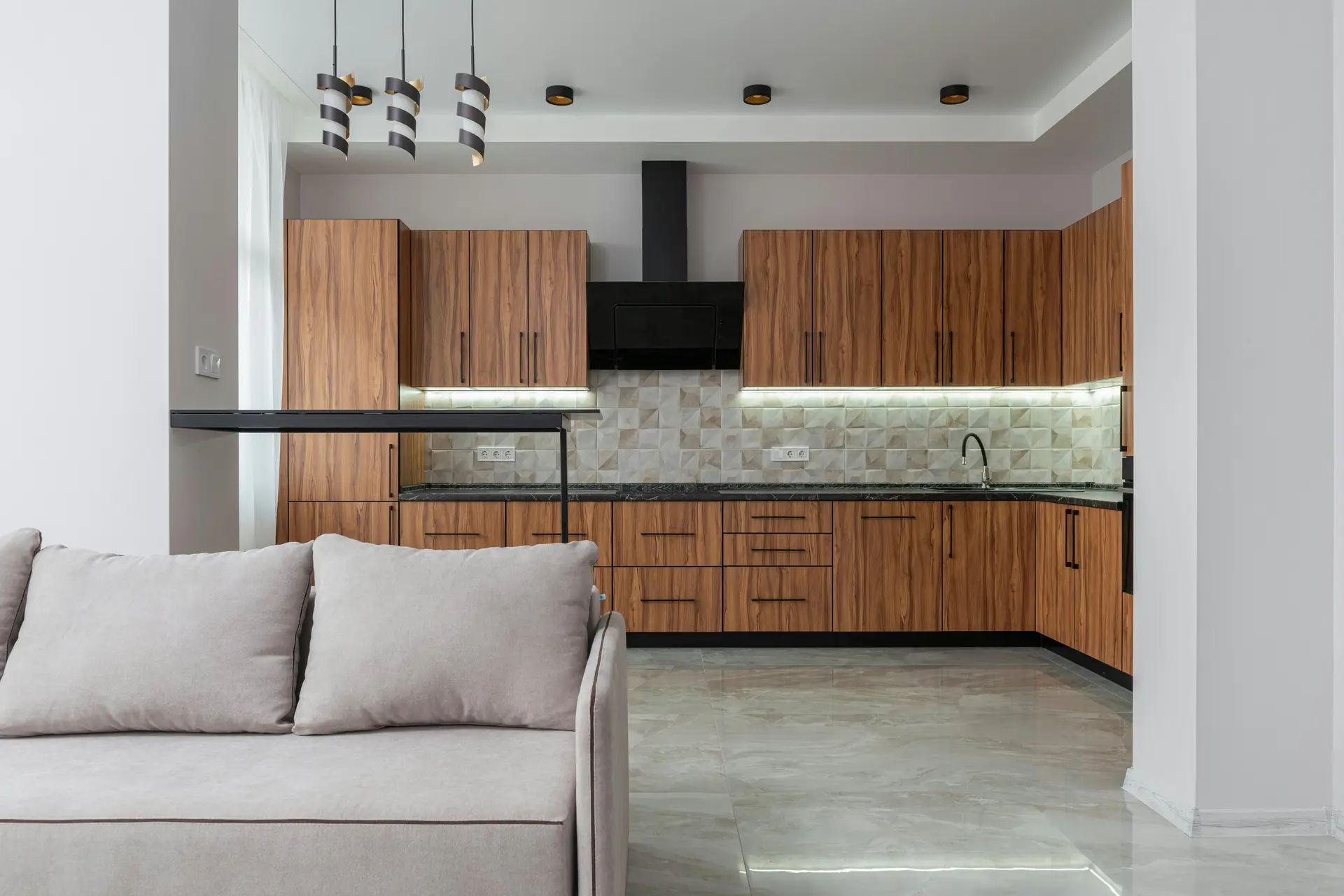 Open-plan modern kitchen with custom wood cabinetry connected to a stylish living area