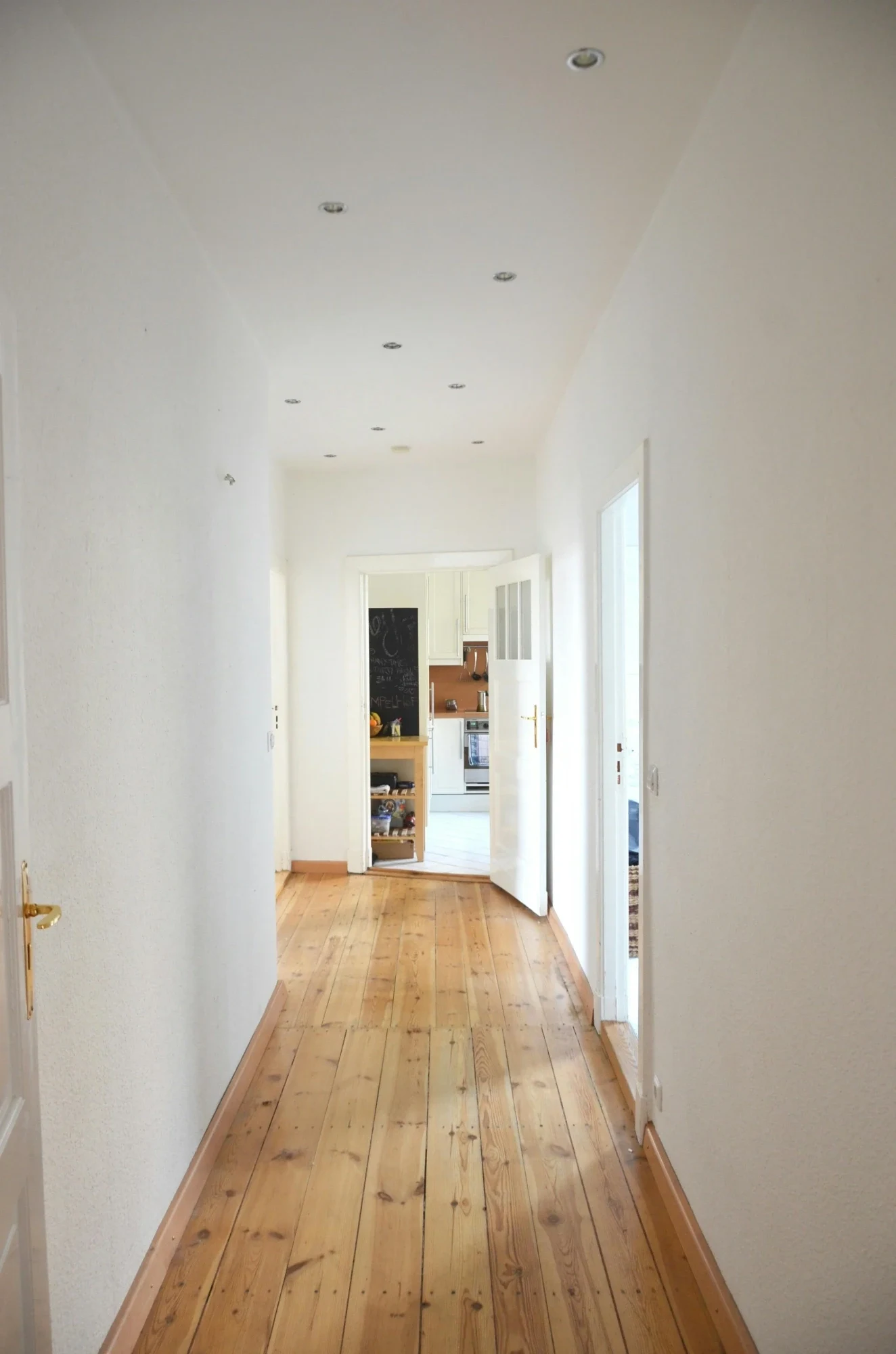 Minimal interior hallway with wooden flooring and modern white doors
