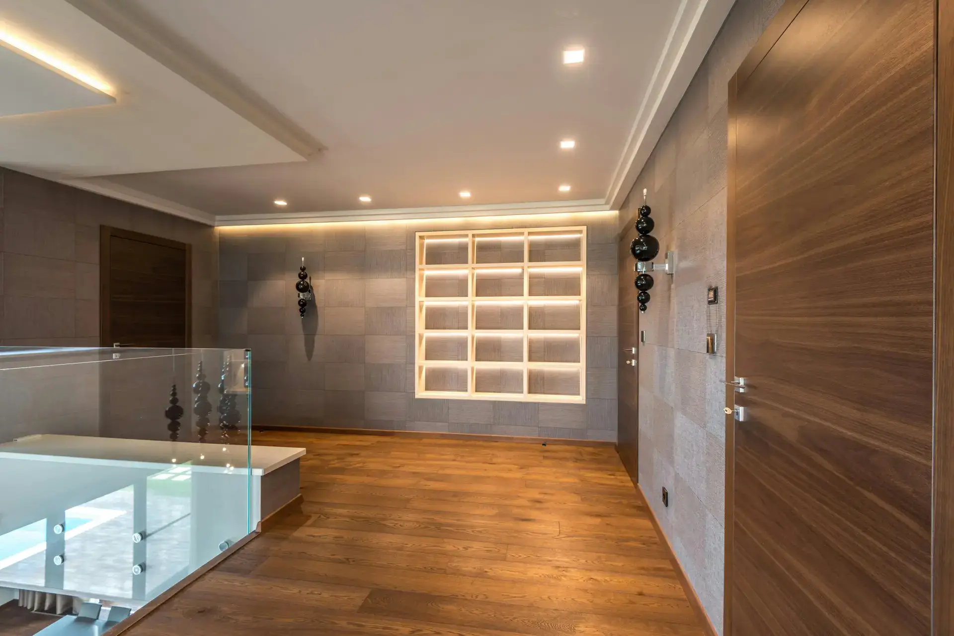 Contemporary interior hallway with wood flooring, ambient lighting, and modern wall finishes