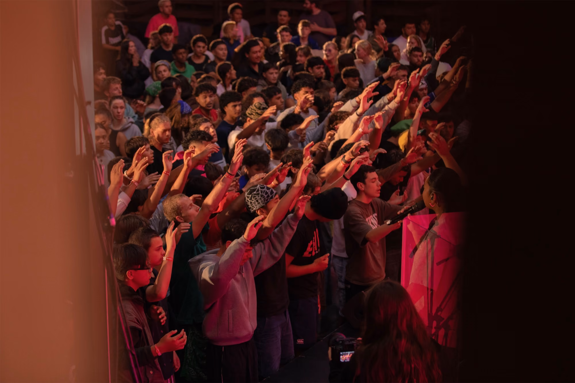 Young people worshipping with hands raised at Summer Revolution