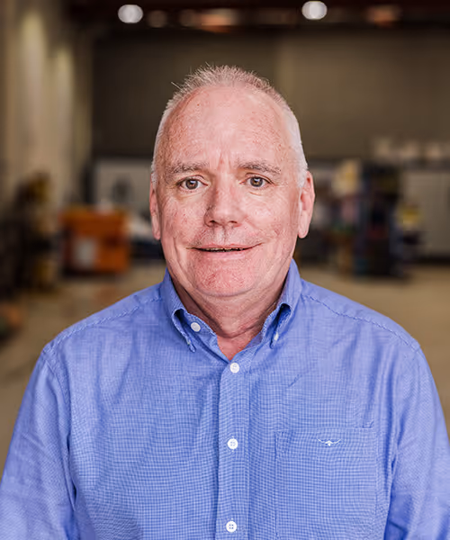 Portrait of an male manager in a blue shirt against a workshop background