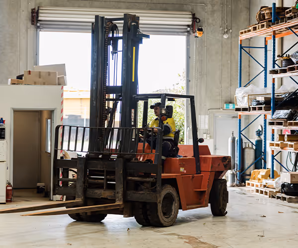 Forklift placing a pallet inside a warehouse facility