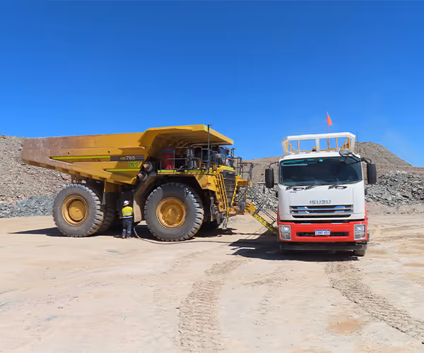 Mining dump truck parked in a pit overlooking red rock terrain