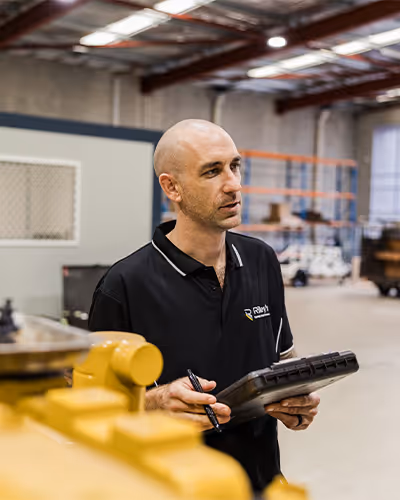 Heavy-duty mine supervisor reviewing site equipment.