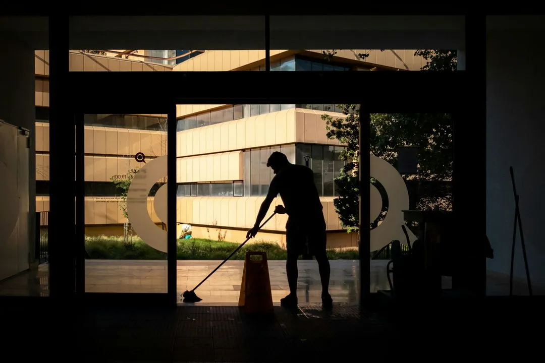 A silhouette of a man cleaning the floor