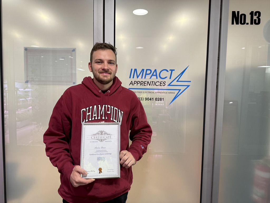 One of Impact's apprentice holding this completion certificate after completing their apprenticeship