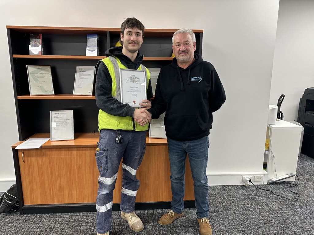 Ian Theobald, OH&S Officer is handing out the completion certificate to one of Impact's Apprentice