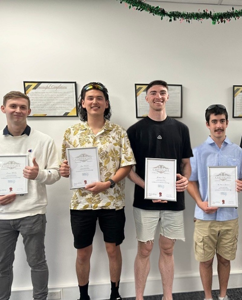 Impact's group of electrical apprentices holding their completion certificate in the Collingwood Officer