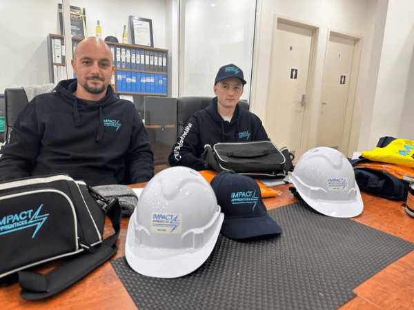 Two of our apprentices sitting in the Impact Apprentices office on to commence their electrical apprenticeship with their PPE displayed on the table