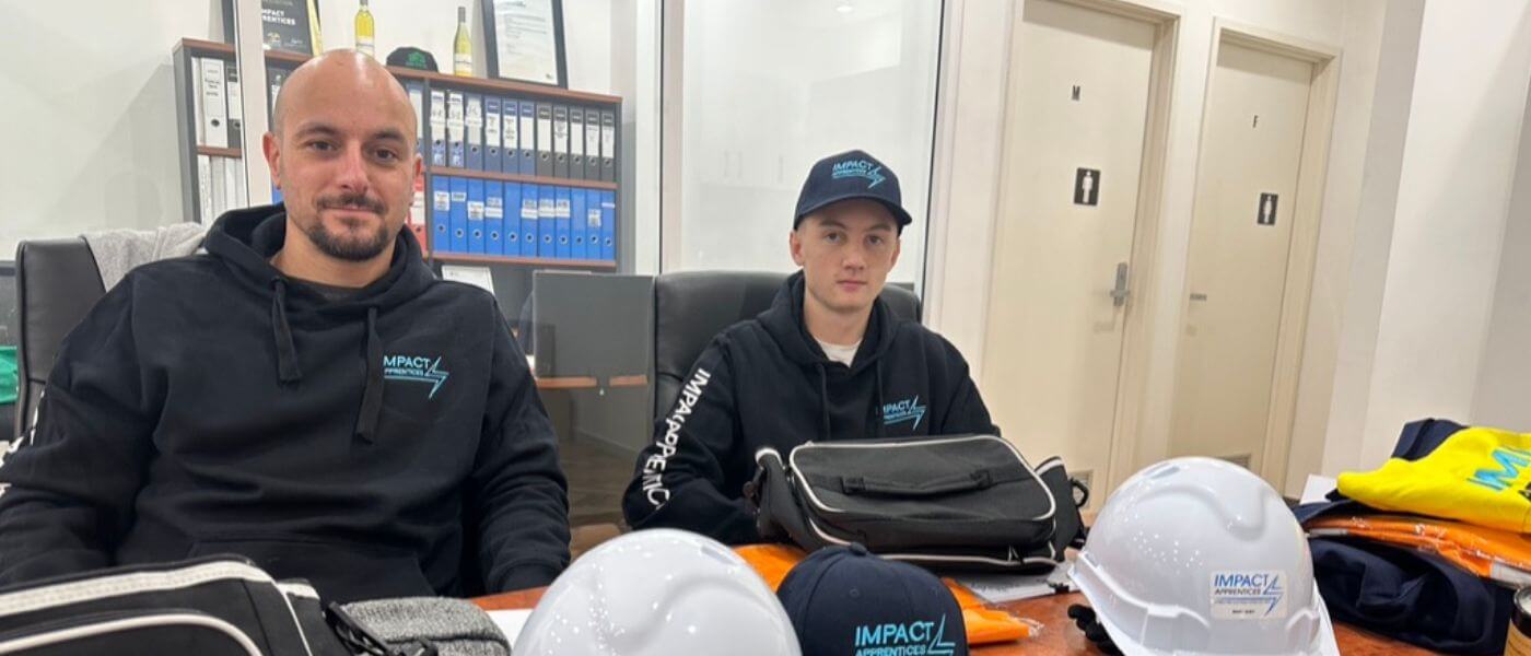 Two of our apprentices sitting in the Impact Apprentices office on to commence their electrical apprenticeship with their PPE displayed on the table