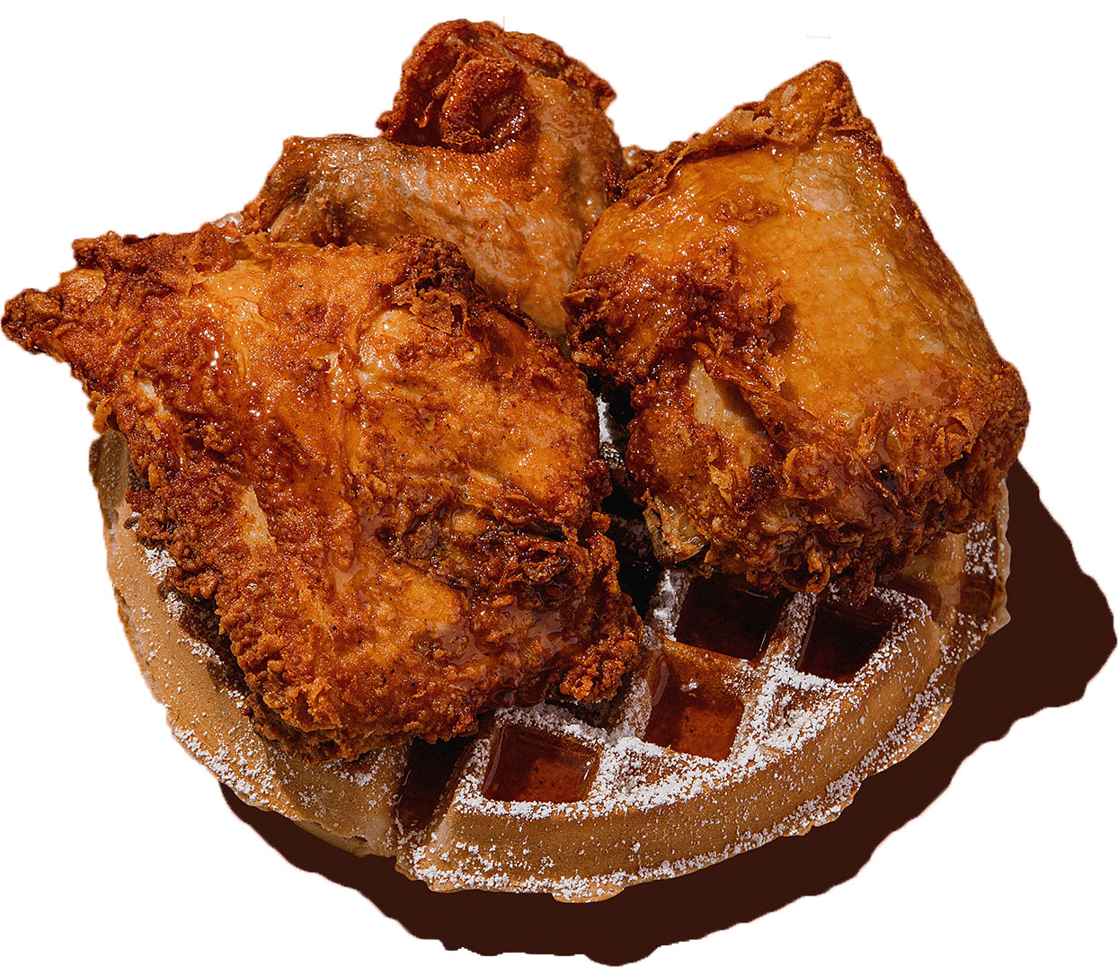 Crispy fried chicken served on fluffy golden waffles with syrup and powdered sugar.