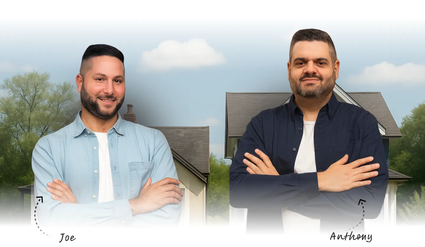 Photograph of a modern house with stone and white siding, and a car in the driveway.