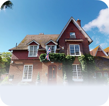 An image of a brick house in Hempstead with steep roof and ivy trim.
