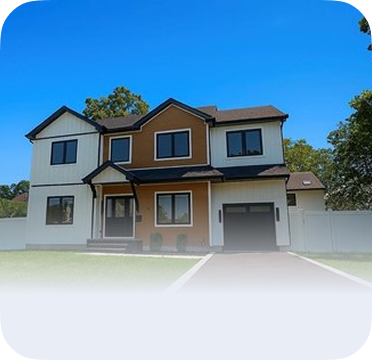An image of a two-story house in Copiague with white and brown exterior and attached garage.