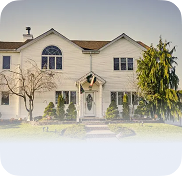 An image of a two-story cream house in Levittown with arched window and front yard.