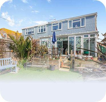 An image of a two-story blue house in Seaford with a backyard patio and garden.