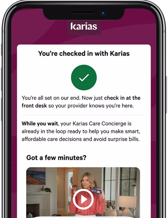 Smartphone screen showing confirmation message for Karias check-in with a green checkmark, instructions to check in at the front desk, and a video thumbnail with a woman holding a card.