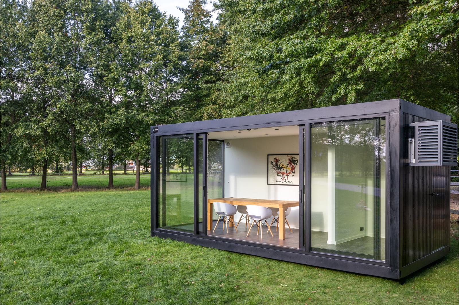 Een unit met glazen wanden en een tafel, ontworpen als multifunctionele unit door ROBCOR.