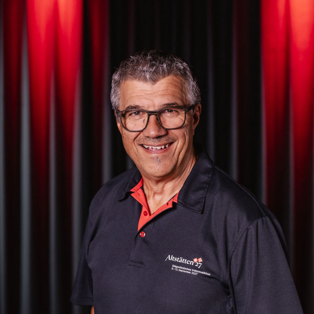 Alex Zenhäusern, member of the organizing committee for the 2027 Swiss Folk Music Festival, portrait photo wearing an Altstätten27 polo shirt