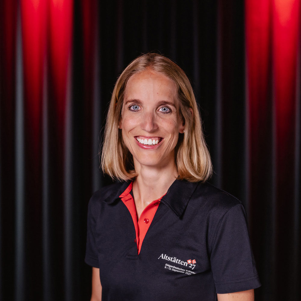 Karin Gschwend, member of the organizing committee for the 2027 Swiss Folk Music Festival, portrait photo wearing an Altstätten27 polo shirt