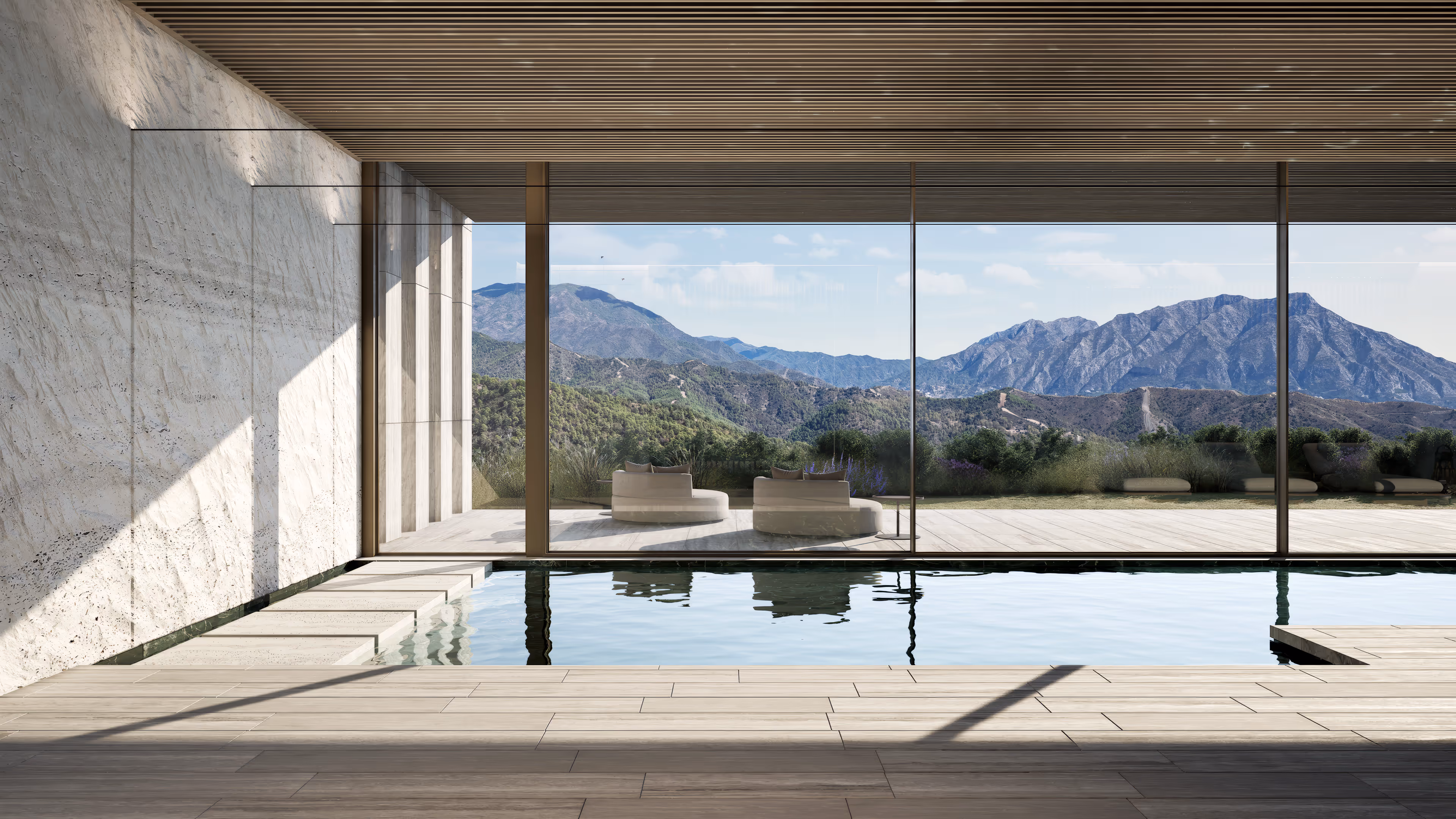 Indoor pool area with glass walls offering a view of mountains and a patio with modern chairs.