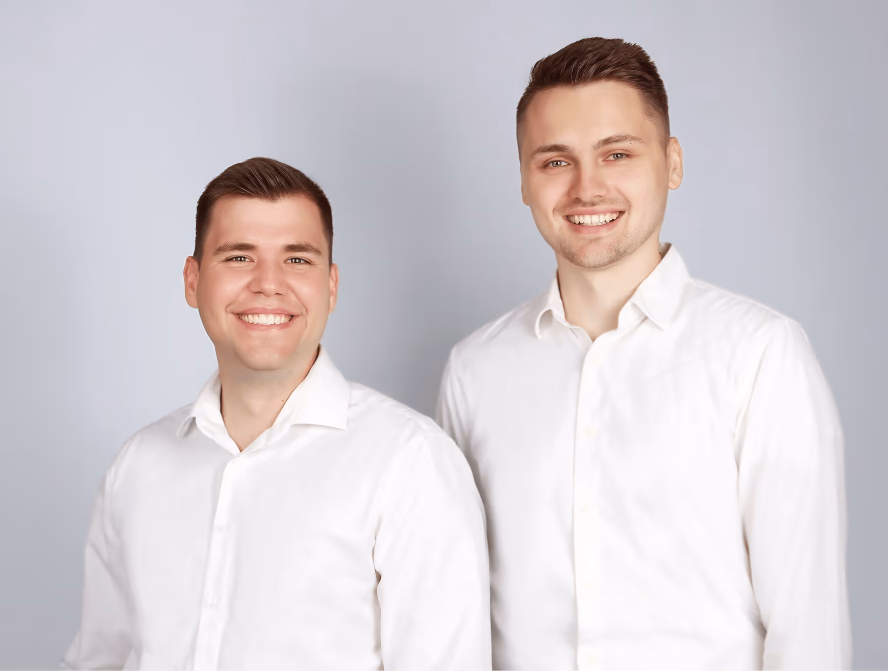 Zwei Männer blicken lächelnd in die Kamera