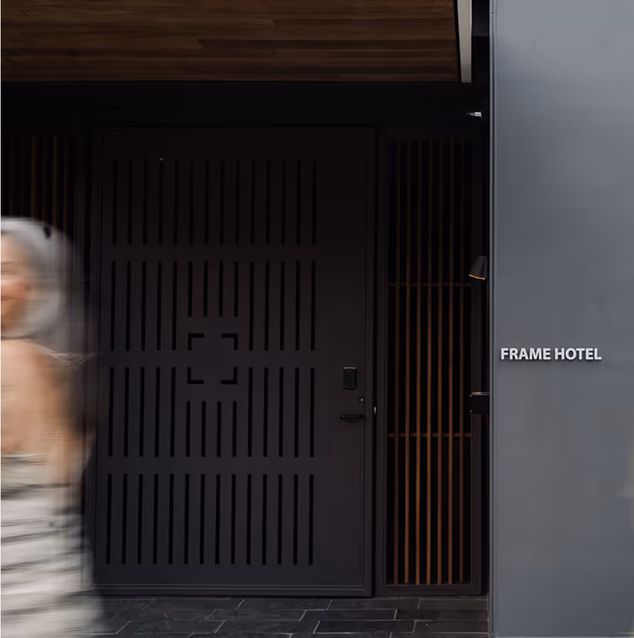 Person walking by Frame Hotel.