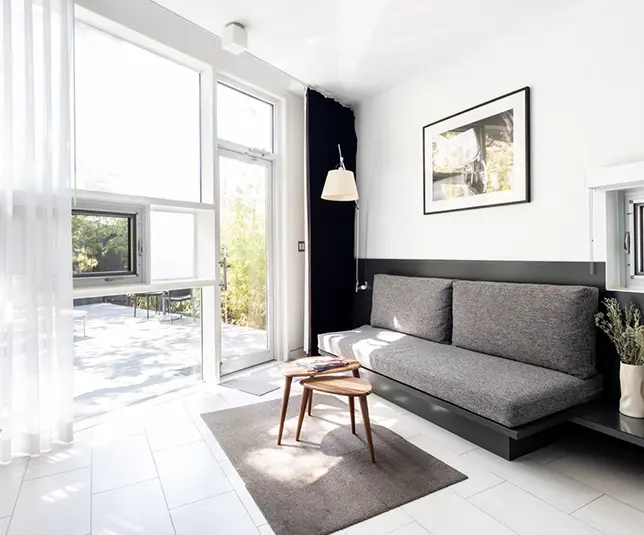 Minimal guestroom with custom oak furniture and window wall.