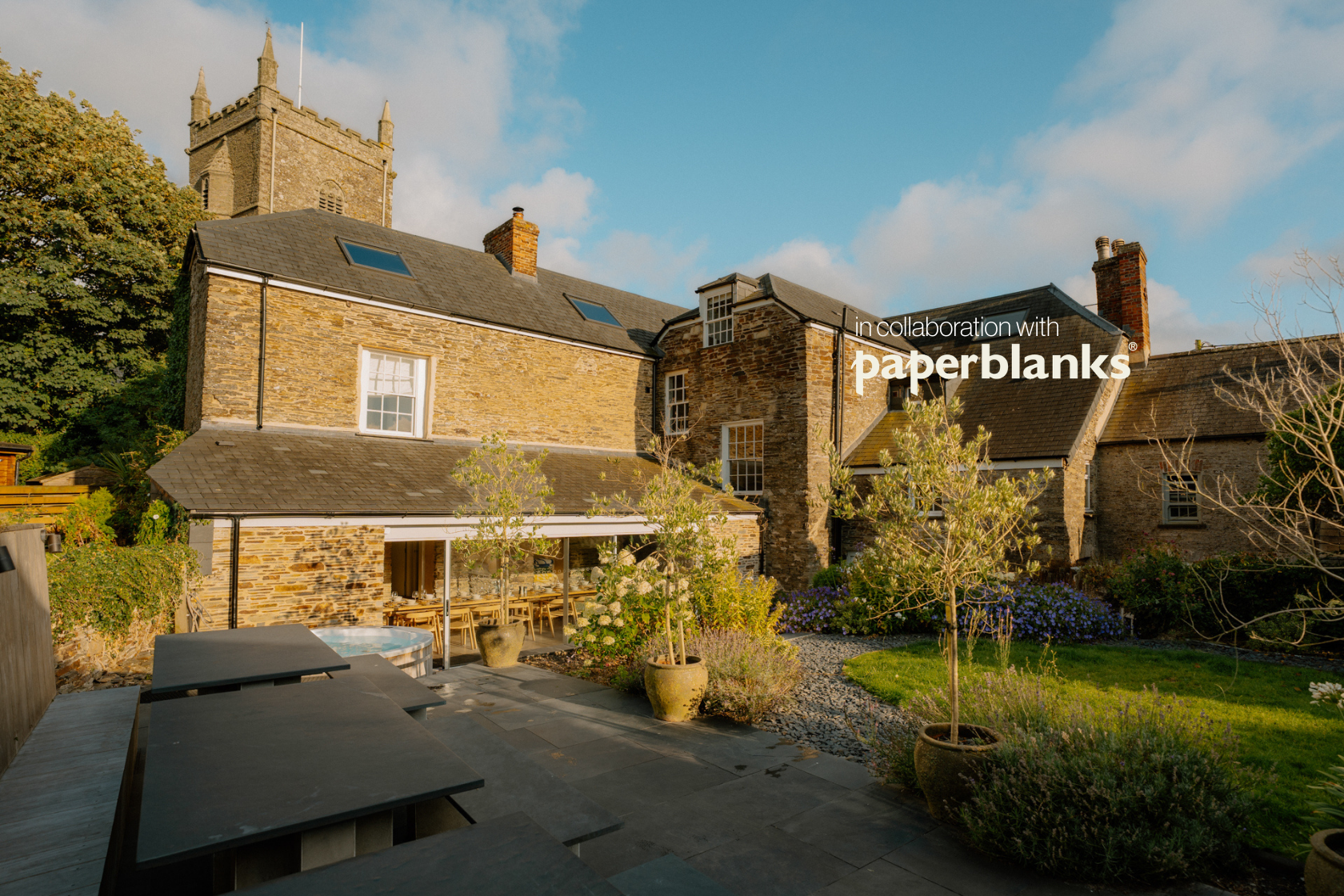 King-size bed decorated with throw pillows and blankets in a contemporary bedroom in Cornwall, England.